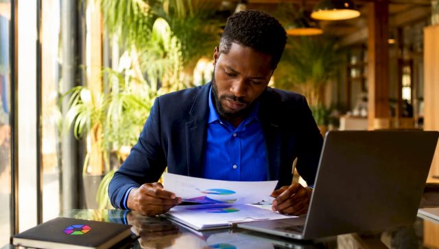 Lors d'une réunion, un professionnel analyse attentivement des documents relatifs aux décisions prises par l'intelligence artificielle.